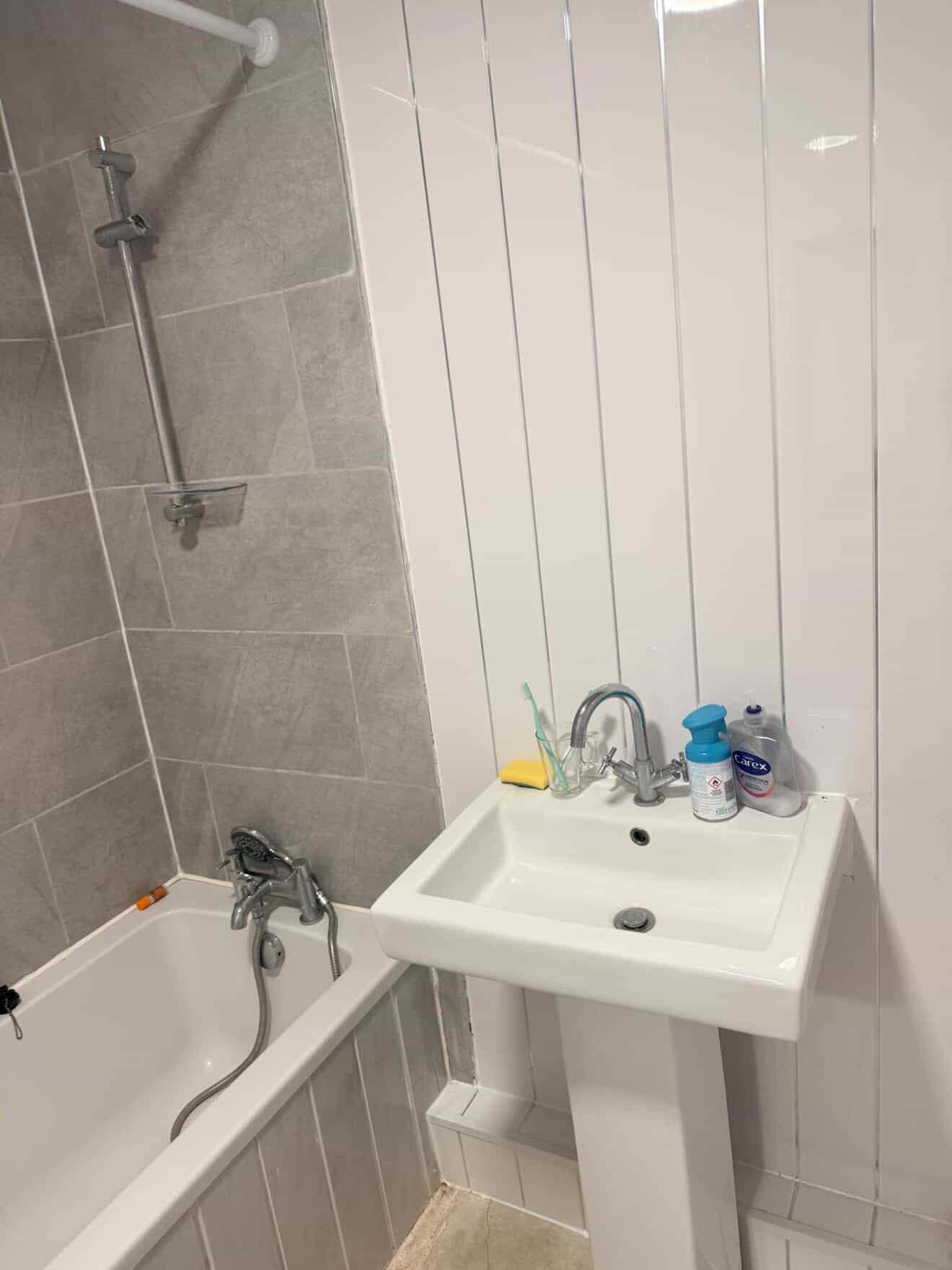 Bathroom sink and bath area before a detailed clean.